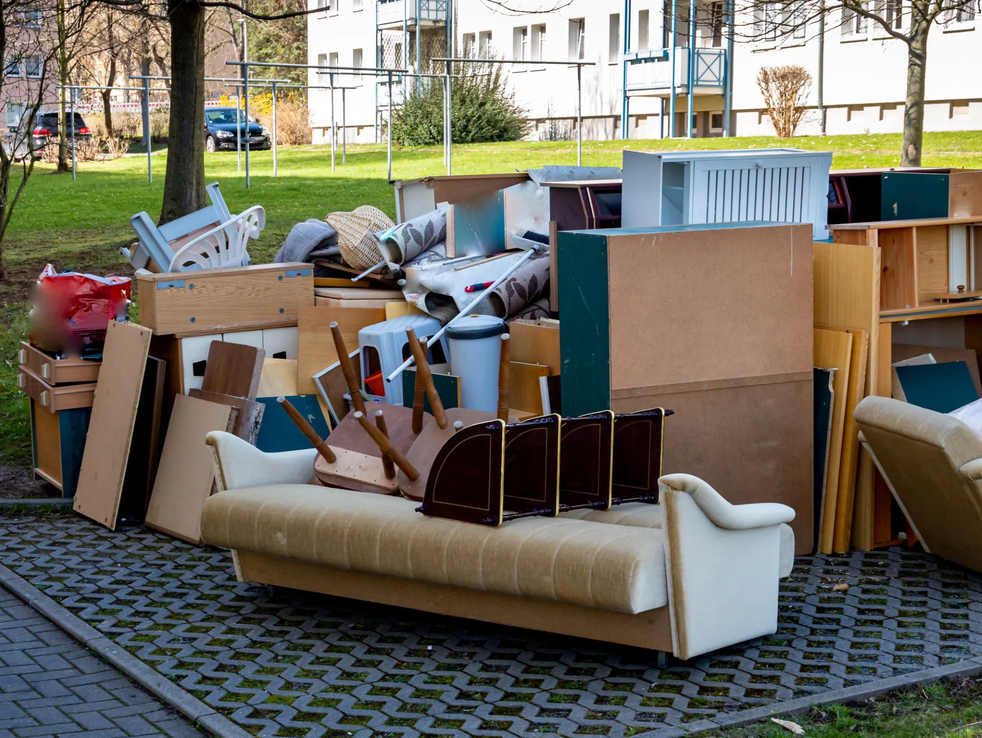Ausgeräumte Möbel und Sperrmüll stehen nach einer Entrümpelung in Wien vor einem Wohnhaus